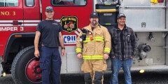 Three NorthIsle firefighters in front of a red fire truck.