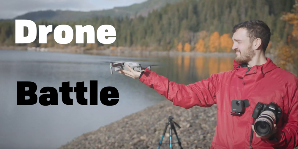 A man in a red jacket carrying a giant camera holds a drone up so the pilot can launch it from his hand.