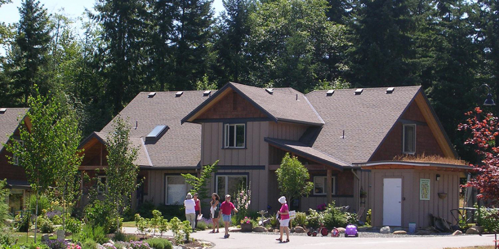 Folks walk outside the buildings in Creekside Commons on a sunny day.